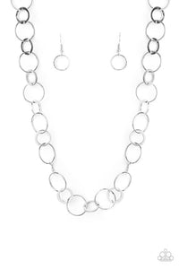 Dainty silver hoops and rings delicately link into a chic chain, creating simplistic shimmer below the collar. Features an adjustable clasp closure.  Sold as one individual necklace. Includes one pair of matching earrings.