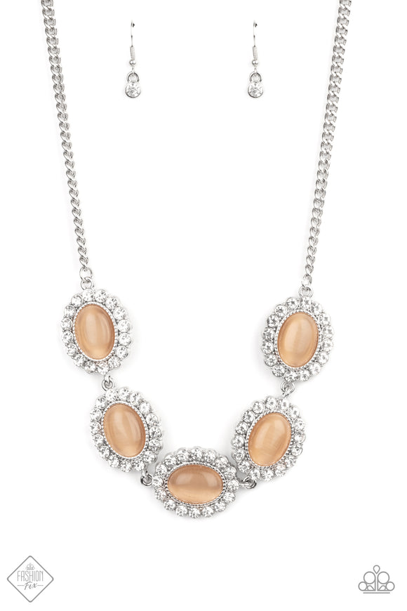 Dotted with glowing Peach Nougat cat's eye stone centers, glassy white rhinestone encrusted frames glamorously link below the collar in a sparkly statement-making fashion. Features an adjustable clasp closure.  Sold as one individual necklace. Includes one pair of matching earrings.