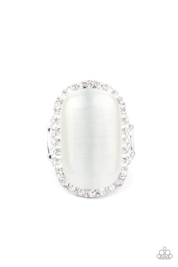 An oversized white cat's eye stone sits atop an icy silver frame bedazzled in blinding white rhinestones for a luxurious look. Features a stretchy band for a flexible fit.  Sold as one individual ring.