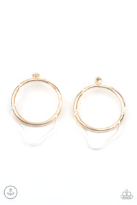 An asymmetrical piece of clear acrylic overlaps a glistening gold hoop, creating a bold display. Earring attaches to a standard post fitting.  Sold as one pair of post earrings.