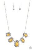 Bordered in glassy white rhinestones, glowing yellow cat's eye stone frames delicately increase in size as they link below the collar, creating an enchanting display. Features an adjustable clasp closure.  Sold as one individual necklace. Includes one pair of matching earrings.