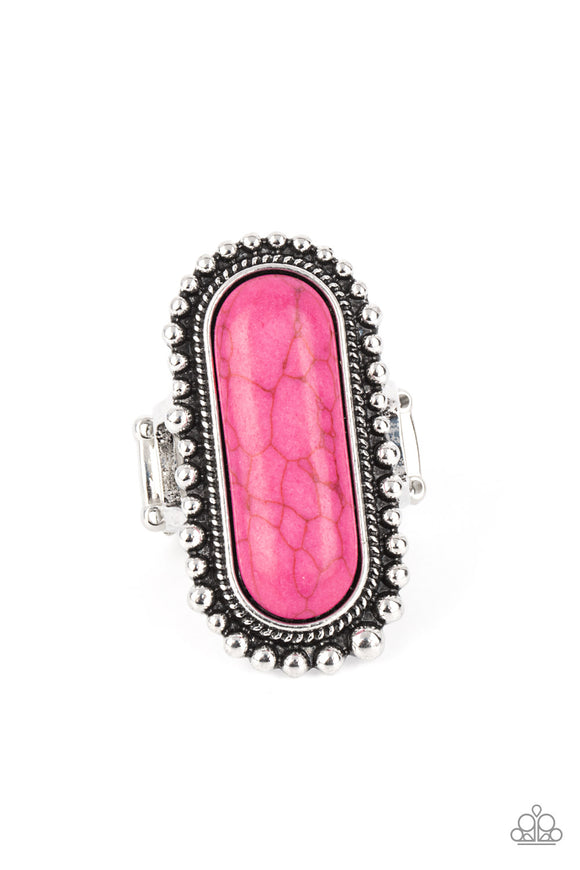 An oblong pink stone is nestled inside an oversized studded silver frame, creating a colorfully rustic centerpiece atop the finger. Features a stretchy band for a flexible fit.  Sold as one individual ring.