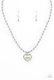 Featuring a pearly Green Ash center, a charming heart pendant glides along a strand of silver beads below the collar for a romantic flair. Features an adjustable clasp closure.  Sold as one individual necklace. Includes one pair of matching earrings.