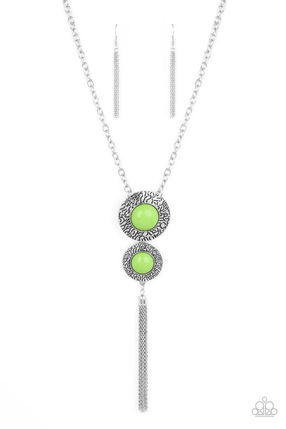 Stamped in vein-like patterns, two oversized silver discs are dotted with bubbly green beaded centers at the bottom of a chunky silver chain. A shimmery silver chain tassel swings from the bottom of the stacked pendant, adding playful movement. Features an adjustable clasp closure. Features an adjustable clasp closure.