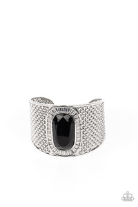 An oversized black gem is pressed into the center of a thick silver cuff embossed in diamond-like textures, creating a bold tribal inspired centerpiece around the wrist.  Sold as one individual bracelet.