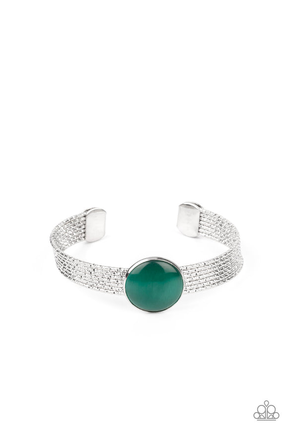 A glassy green cat's eye stone frame sits atop a layered silver cuff that is etched in shimmery textures, creating a glittery centerpiece.  Sold as one individual bracelet.