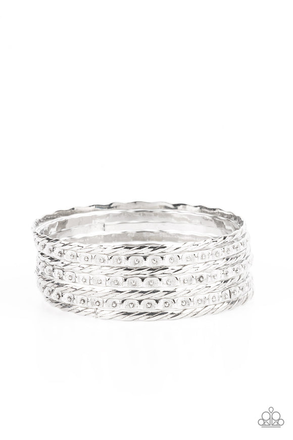 Embossed in slanted ribbons of textured and studded hammered patterns, trios of mismatched silver bangles stack across the wrist for an intense industrial vibe.  Sold as one set of six bracelets.