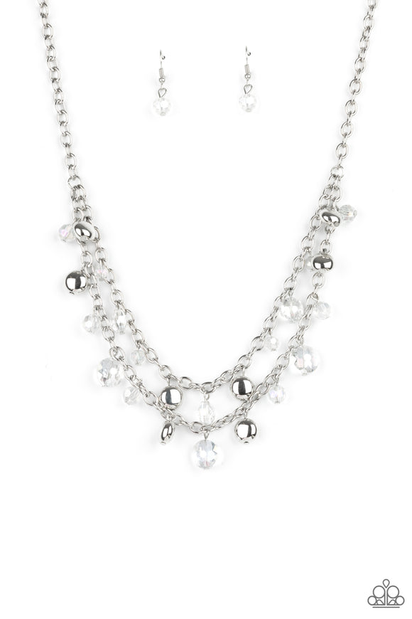 Flat silver beads and iridescent white crystal-like beads swing from the bottoms of two silver chains, creating ethereal layers below the collar. Features an adjustable clasp closure.  Sold as one individual necklace. Includes one pair of matching earrings.