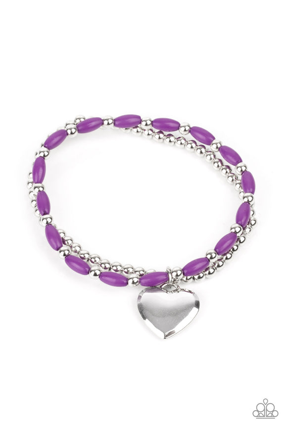 A shiny silver heart dangles from a strand of playful purple beads. It is paired with a strand of round silver beads threaded along a stretchy band for a whimsical charm around the wrist.  Sold as one pair of bracelets.
