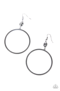 A slim oversized silver ring, highlighted by two concentric circles of dotted texture, dangles from an oval hematite gem for an edgy refined look. Earring attaches to a standard fishhook fitting.  Sold as one pair of earrings.