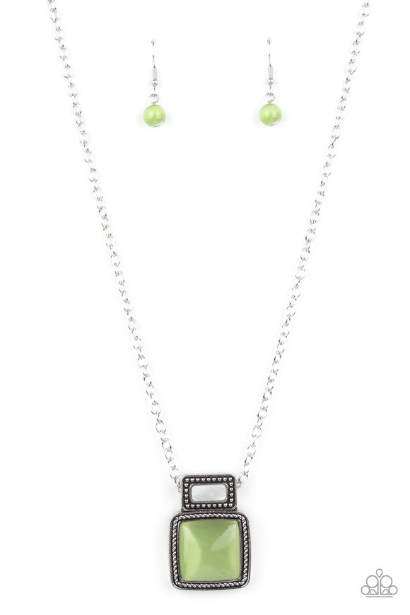 A shell-like accent is pressed into the center of a studded silver frame that sits atop a silver rope-like frame that is dotted with a square Green Ash cat's eye stone. The colorful pendant swings from a shiny silver chain, creating an ethereal pendant below the collar. Features an adjustable clasp closure.  Sold as one individual necklace. Includes one pair of matching earrings.
