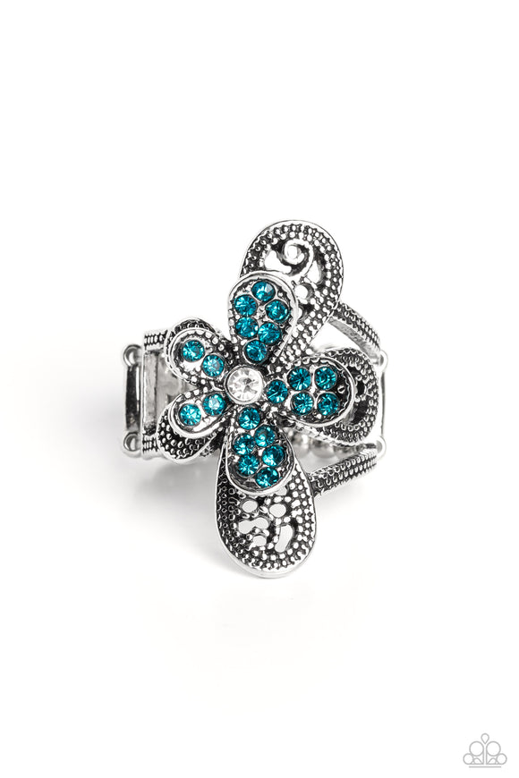 Dotted with a dainty white rhinestone center, silver petals overlaid with glittery blue rhinestones, sit atop studded silver filigree petals, creating a frilly floral centerpiece atop the finger. Features a stretchy band for a flexible fit.  Sold as one individual ring.