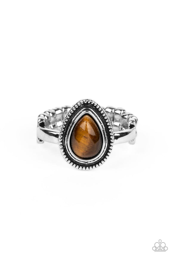 A tiger's eye teardrop stone is pressed into the center of a textured silver frame atop a dainty silver band, creating an earthy statement piece. Features a dainty stretchy band for a flexible fit. As the stone elements in this piece are natural, some color variation is normal.  Sold as one individual ring.