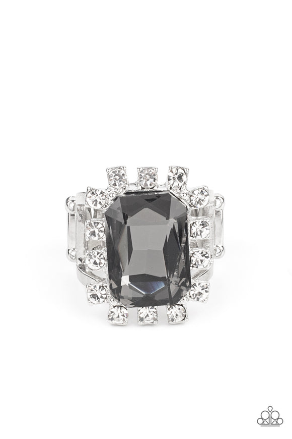 Featuring dainty silver square fittings, an explosion of glassy white rhinestones fans out from a dramatically oversized emerald cut smoky rhinestone center, creating a stellar centerpiece atop the finger. Features a stretchy band for a flexible fit.  Sold as one individual ring.
