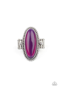 Featuring a glassy iridescence, an oval purple acrylic bead is pressed into the center of textured silver fittings, creating a mystical centerpiece atop the finger. Features a dainty stretchy band for a flexible fit.  Sold as one individual ring.