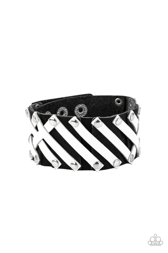 Pieces of white leather are studded in place across the front of a pieced together black leather band, creating edgy crisscrossed texture around the wrist. Features an adjustable snap closure.  Sold as one individual bracelet.