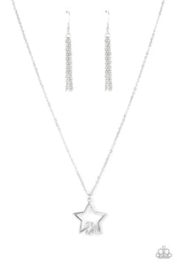 The bottom of a glistening silver star frame delicately overlaps with a dramatically oversized white gem, creating a stellar patriotic inspired sparkle beneath the collar. Features an adjustable clasp closure.  Sold as one individual necklace. Includes one pair of matching earrings.