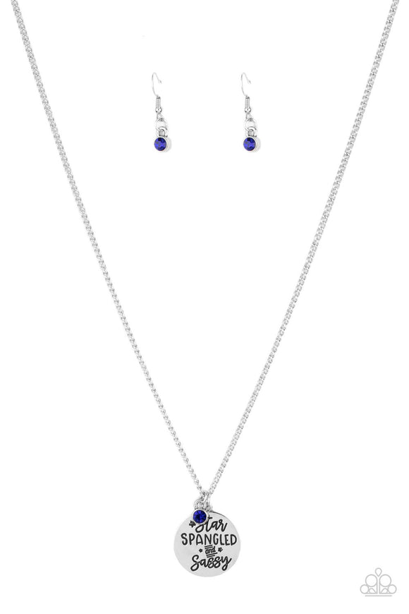 Infused with a solitaire blue rhinestone, a shiny silver disc is stamped in the patriotic phrase, 