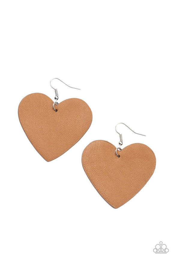 A tan leather heart frame swings from the ear for a flirtatiously neutral pop of color. Earring attaches to a standard fishhook fitting.  Sold as one pair of earrings.