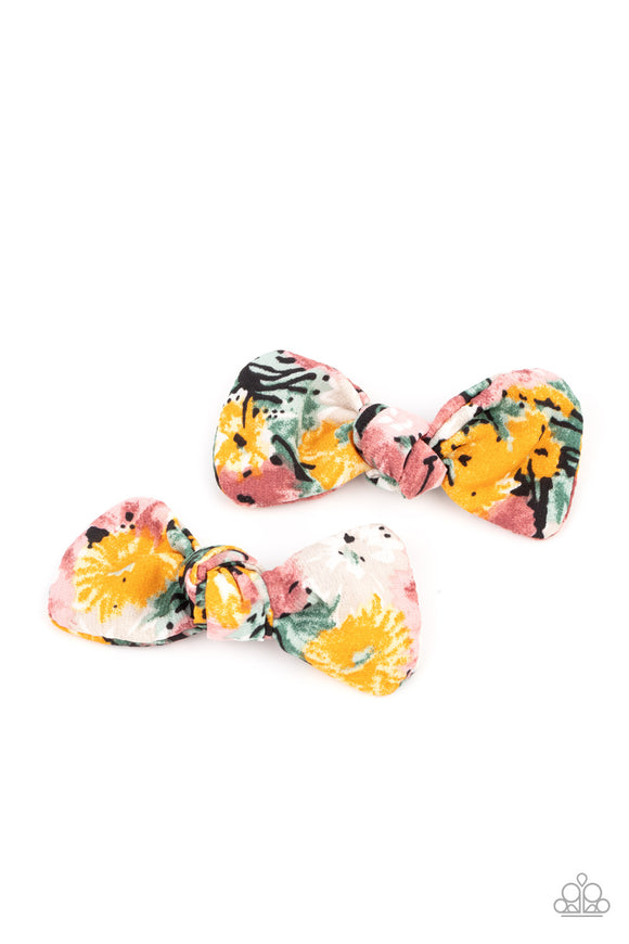 Featuring hints of yellow, green, pink and gray, colorful pieces of fabric delicately knot into a pair of whimsical hair bows for a seasonal look. Features standard hair clips on the back.   Featured inside The Preview at GLOW! Sold as one pair of hair clips.