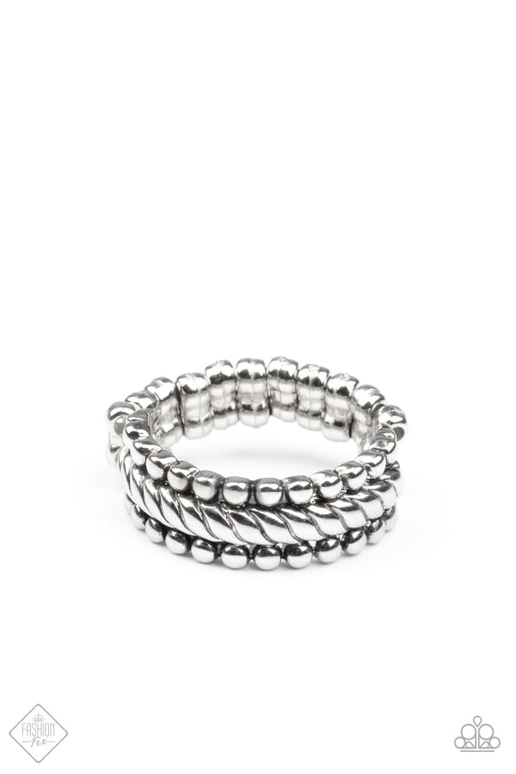 A twisted silver band is flanked by rows of antiqued silver studs, creating a rustically layered look across the finger. Features a dainty stretchy band for a flexible fit.
