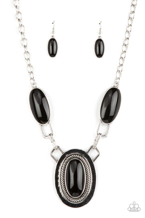 Featuring abstract square fittings, a pair of oblong black beaded frames link to a dramatically oversized silver pendant below the collar. Bordered in rope-like texture, the hammered pendant features a matching black bead for a powerful pop of color. Features an adjustable clasp closure.  Sold as one individual necklace. Includes one pair of matching earrings.