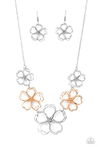 Glistening silver and rose gold wires delicately twist into oversized blossoms. Gradually increasing in size, the 3D frames elegantly pop beneath the collar. Features an adjustable clasp closure.  Sold as one individual necklace. Includes one pair of matching earrings.