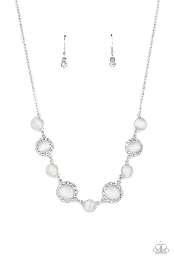 Featuring classic silver fittings or white rhinestone encrusted silver frames, a mesmerizing collection of glowing white cat's eye stones delicately link below the collar for an ethereal pop of color. Features an adjustable clasp closure.  Sold as one individual necklace. Includes one pair of matching earrings.