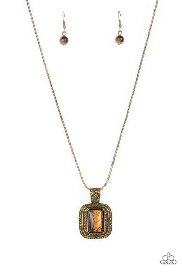 A rectangular tiger's eye stone is pressed into the center of a studded brass frame bordered in decorative filigree at the bottom of a rounded brass snake chain, creating a mystical talisman below the collar. Features an adjustable clasp closure.  Sold as one individual necklace. Includes one pair of matching earrings.
