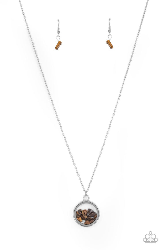 Infused with a sleek silver fitting, an earthy collection of dainty tiger's eye stones are encased in a glassy frame at the bottom of a dainty silver chain. Features an adjustable clasp closure.  Sold as one individual necklace. Includes one pair of matching earrings.