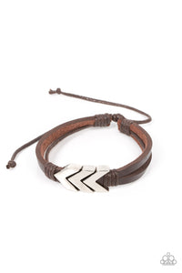 A rustic silver chevron-like arrow centerpiece is knotted in place along strips of brown leather bands, creating an urban statement around the wrist. Features an adjustable sliding knot closure.  Sold as one individual bracelet.