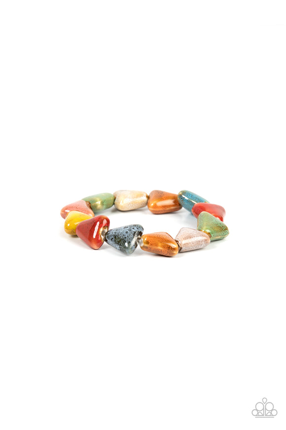Painted in distressed multicolored finishes, ceramic beads shaped like shark teeth are threaded along a stretchy band around the wrist for a seasonal flair.  Sold as one individual bracelet.