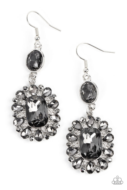 Dainty hematite rhinestones and teardrop smoky gems fan out from an oversized smoky emerald cut gem at the bottom of a solitaire oval smoky gem, resulting in a glamorously glitzy lure. Earring attaches to a standard fishhook fitting.  Sold as one pair of earrings.