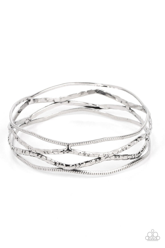 Textured and embossed in nature inspired patterns, rustic silver bars zigzag around the wrist as they stack into a wildly layered bangle.  Sold as one individual bracelet.