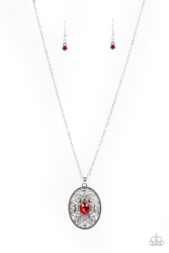 Dainty white rhinestones are sprinkled across silver vine-like filigree that whirls around an oval red gem center inside of a studded silver frame, resulting in a whimsical pendant at the bottom of a silver chain. Features an adjustable clasp closure.  Sold as one individual necklace. Includes one pair of matching earrings.