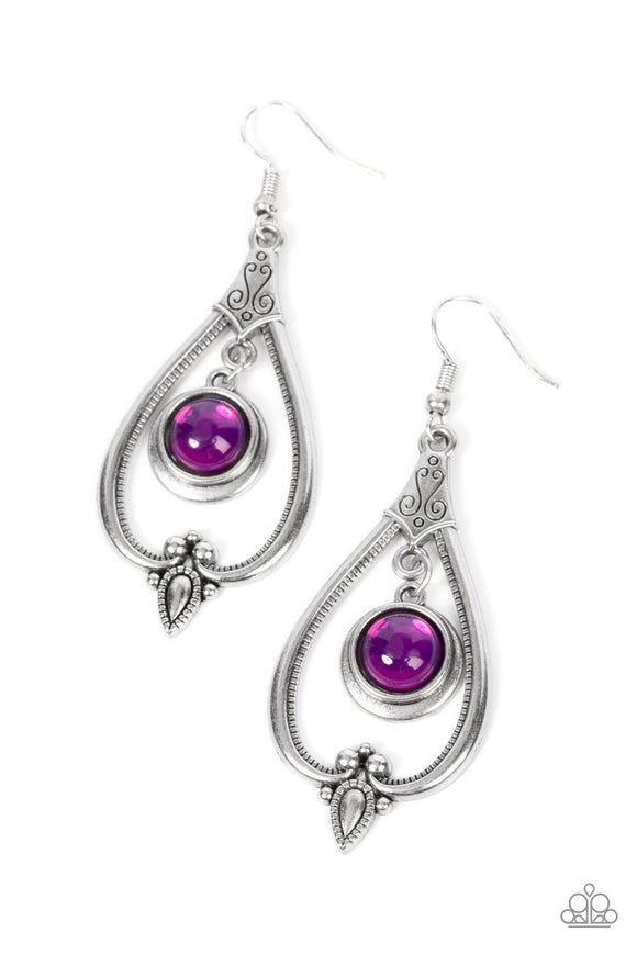 A glassy purple bead is pressed into a stacked silver frame as it swings from the bottom of an ornate silver teardrop, resulting in a regal pop of color. Earring attaches to a standard fishhook fitting.  Sold as one pair of earrings.