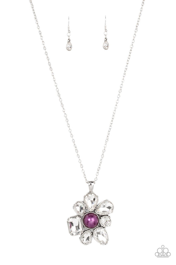 Encased in pronged silver fittings, a mismatched collection of oversized teardrop, round, and emerald cut rhinestones asymmetrically blooms from a bubbly purple pearl drop center for a surprisingly sparkly floral pendant at the bottom of a silver chain. Features an adjustable clasp closure.  Sold as one individual necklace. Includes one pair of matching earrings.