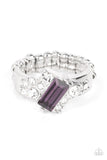 An emerald cut purple rhinestone slants across the front of an asymmetrical silver frame dotted in glassy white rhinestones, resulting in a radiant centerpiece atop the finger. Features a stretchy band for a flexible fit.  Sold as one individual ring.