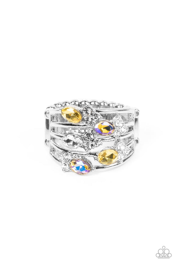 Infused with clusters of dainty white rhinestones, a glitzy collection of yellow, iridescent, and white oval rhinestones are sprinkled across layers of silver bands, creating an ethereal sparkle across the finger. Features a dainty stretchy band for a flexible fit.   Featured inside The Preview at GLOW! Sold as one individual ring.