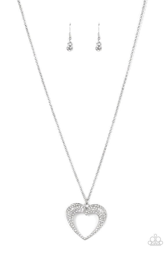 A flared silver heart is encrusted in glassy white rhinestones, resulting in a romantic shimmer at the bottom of an extended silver chain. Features an adjustable clasp closure.  Sold as one individual necklace. Includes one pair of matching earrings.