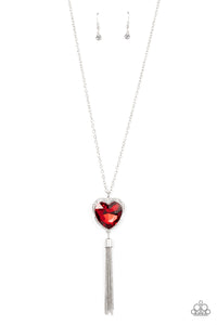 Bordered in a ribbon of glassy white rhinestones, an oversized red heart-shaped gem seemingly floats at the bottom of an extended silver chain. A shimmery silver chain tassel dances from the bottom of the sparkly pendant for a flirtatious finish. Features an adjustable clasp closure.  Sold as one individual necklace. Includes one pair of matching earrings.