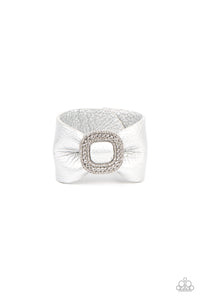 Brushed in a shimmery silver finish, a thick pleather band delicately knots around the wrist. Stacked with brilliant white rhinestones, a dramatic silver buckle sparkles at the center of the wrist for a dramatic finish. Features an adjustable snap closure.