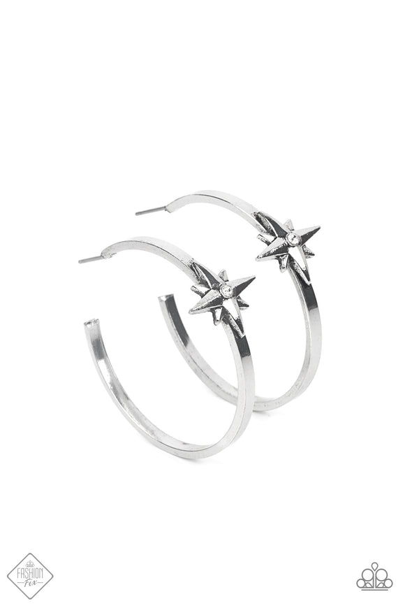 A three-dimensional silver star, dotted with a single dainty white rhinestone, is affixed to the front of a curved silver bar, forming an out-of-this-world hoop earring. Hoop measures approximately 1½ inches.  Sold as one pair of hoop earrings.