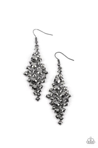 Encased in pronged gunmetal fittings, a mismatched collection of smoky hematite rhinestones tumble into a clustered lure for a smoldering shimmer. Earring attaches to a standard fishhook fitting.  Sold as one pair of earrings.