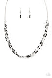 A dainty collection of faceted silver beads, black seed beads, and silver cubes are threaded along multiple strands of silver wire below the collar, creating clustered layers. Features an adjustable clasp closure.  Sold as one individual necklace. Includes one pair of matching earrings.