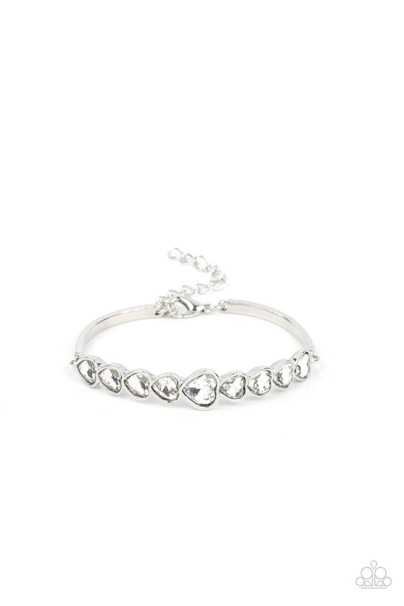 Attached to silver bars, a sparkling series of heart cut white gems are encased in glistening silver frames that curve into a flirtatious centerpiece atop the wrist. Features an adjustable clasp closure.  Sold as one individual bracelet.