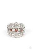 Layers of dainty silver bands, encrusted with sparkling white rhinestones, are accented with a trio of petite brown pearls on the centermost band. The stacked layers sweep across the finger, making an exquisite centerpiece. Features a stretchy band for a flexible fit.  Sold as one individual ring.