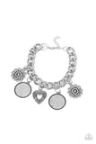 A whimsical collection of silver charms — including an airy heart, flowers, and textured coin-like discs — dance from a chunky silver chain around the wrist, creating a boisterous fringe. Features an adjustable clasp closure.  Sold as one individual bracelet.