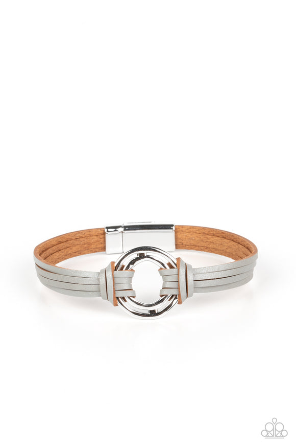 Silver leather strips knot around a soldered pair of asymmetrical hoops, knotting the rustic frame in place at the center of the wrist for a free-spirited finish. Features a magnetic closure.  Sold as one individual bracelet.