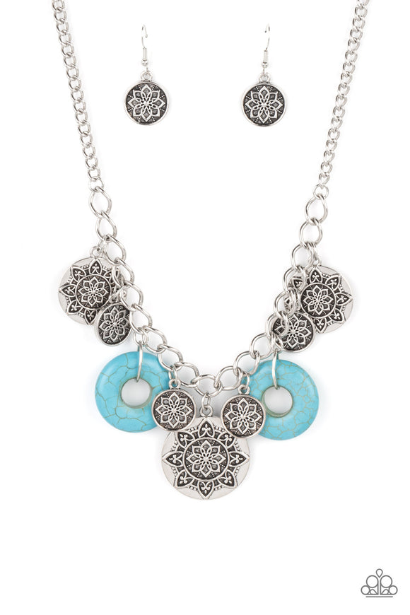 A collection of silver discs, embellished with intricate mandala-like designs, dances along a thick silver chain, with a pair of polished turquoise stone rings adding a pop of color to the rustic design. Features an adjustable clasp closure.  Sold as one individual necklace. Includes one pair of matching earrings.